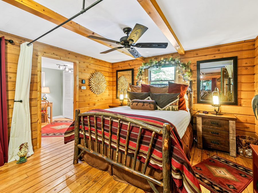 Living room with stone fireplace and porch view