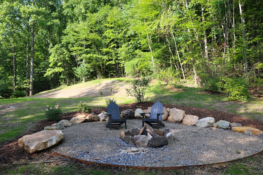Creekside porch with rocking chairs, ferns, and string lights