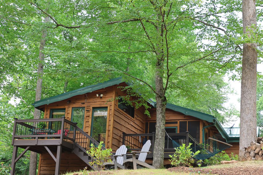 Cabin exterior with multiple porches, hammock, and Adirondack chairs